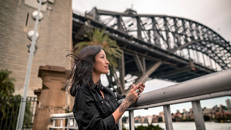 Mujer con un celular en un contexto urbano