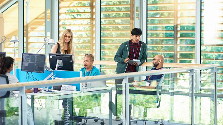 Group of people having meeting in modern large tech company.