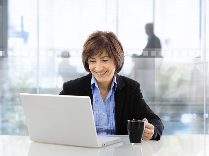 Woman smiling while working on the laptop
