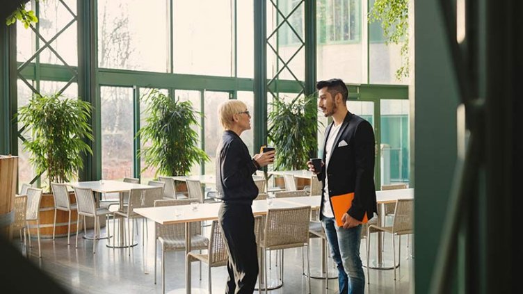 Employees at cafeteria with coffee cup