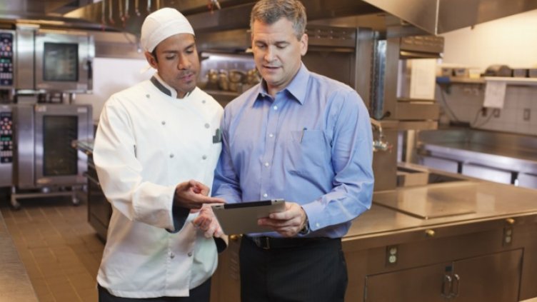 Chef and manager discussing something in the kitchen