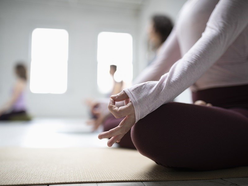 People doing Yoga while sitting on their mats