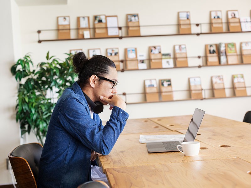 JLL employee attending online meeting with a cup of coffee