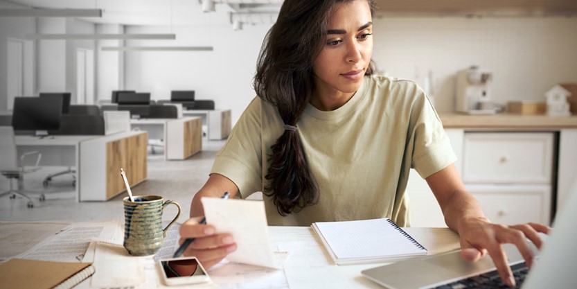 Woman sitting at her desk working on her laptop