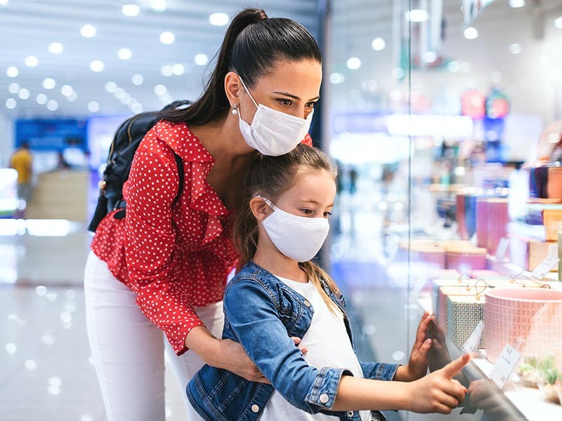 Mother and daughter looking at the price tag in the shopping mall